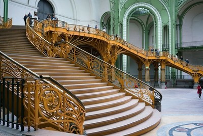 Art Nouveau architecture in Paris. A large staircase intended for many people to use, with fine detailing of botanical motifs in the bannisters.