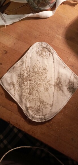 Reusable cotton pad with white fabric and light brown flowers