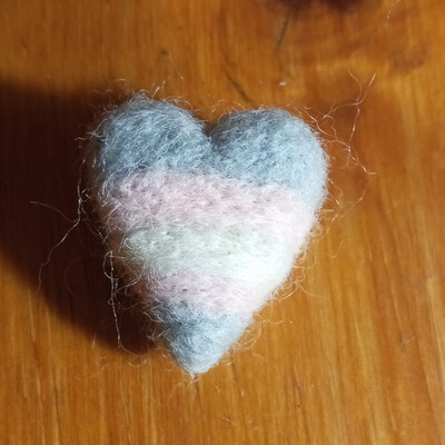 a felt heart with the trans flag colours